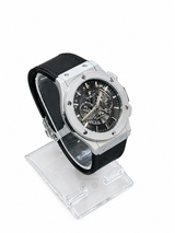 Men's silver skeleton chronograph watch with black leather-style strap, black open-style dial and silver-tone case