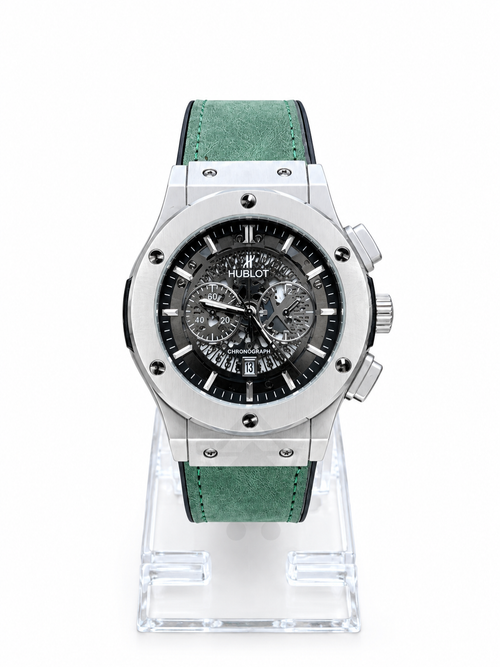 Men's silver skeleton chronograph watch with green leather-style strap and detailed black open-style dial