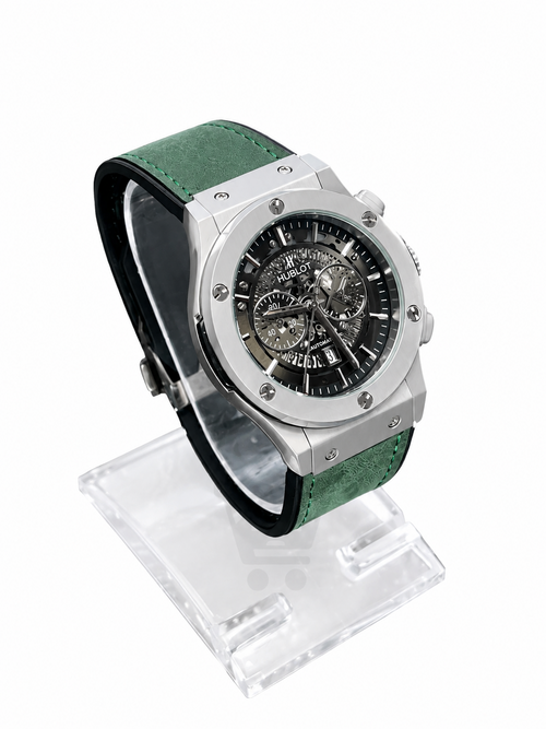 Men's silver skeleton chronograph watch with green leather-style strap and detailed black open-style dial